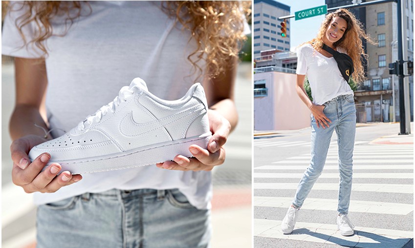 Woman holding Women's Nike Court Vision retro sneaker in white mono.